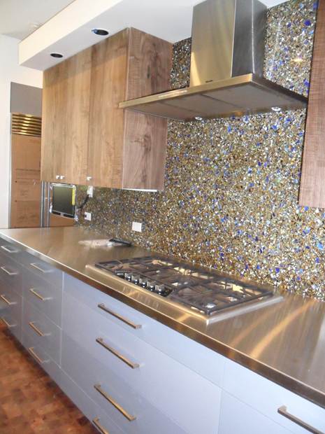 Completed Round Rock kitchen with gray lower cabinets, wood-toned upper cabinets, metal worktop and patterned backsplash.