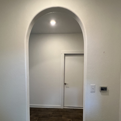 Title: After - Description: Completed rounded architectural opening in a Pflugerville home after the House Doctors of Austin project.
