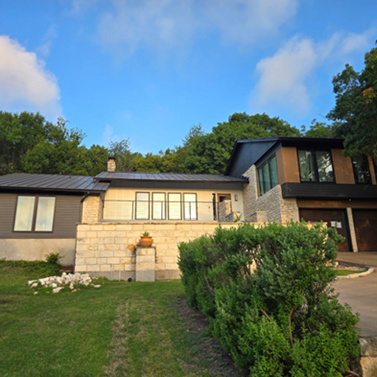 Title: Completed - Description: Completed Austin-area whole-exterior remodel with coordinated siding, trim, windows, railings, and material transitions.