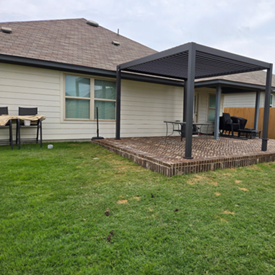 Title: After - Description: Completed brick-finished patio and freestanding pergola in a Leander backyard.
