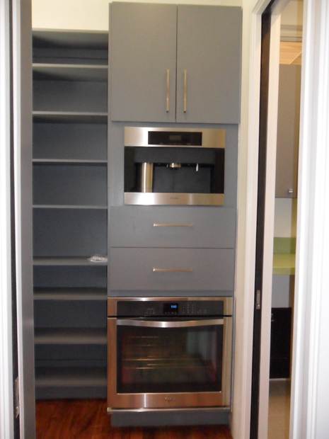 Tall cabinetry with integrated appliances and open shelving in the completed Round Rock kitchen.