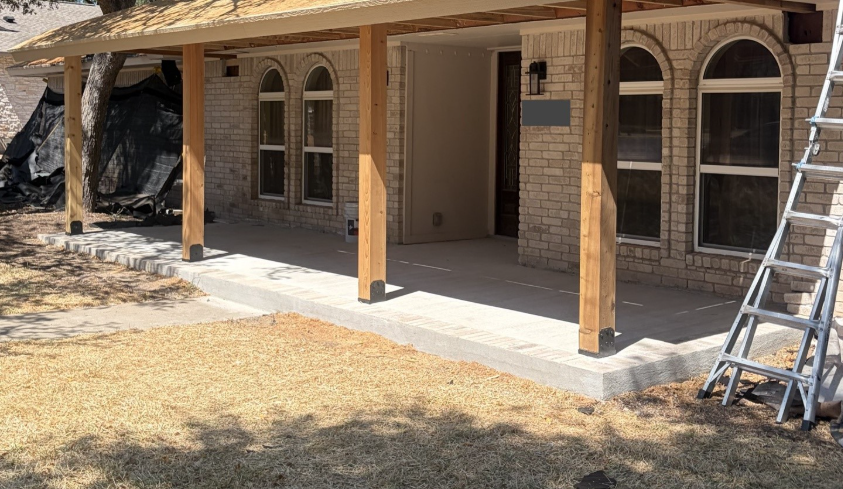 During construction, the new concrete surface and cedar posts establish the wider porch footprint.
During construction, the new concrete surface and cedar posts establish the wider porch footprint.