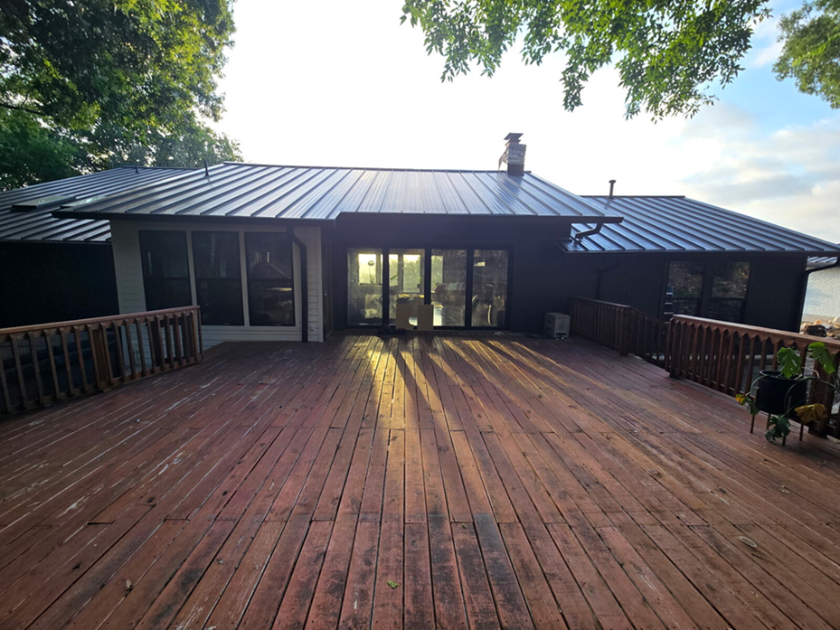 Rebuilt rear deck at sunset connecting a broad outdoor living area to the remodeled exterior.