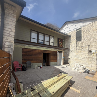 Title: In Progress - Description: Austin-area exterior remodel in progress with facade and deck work underway.