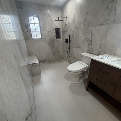 Title: After - Description: Completed Round Rock bathroom with a walk-in shower, large-format wall tile, vanity, and updated finishes.