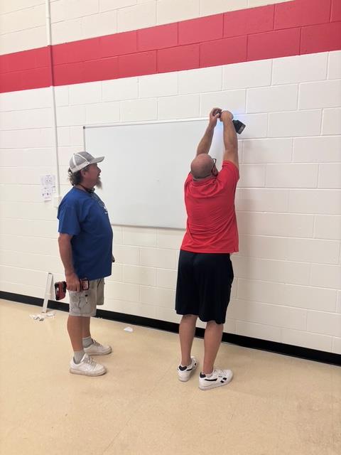 men hanging white board